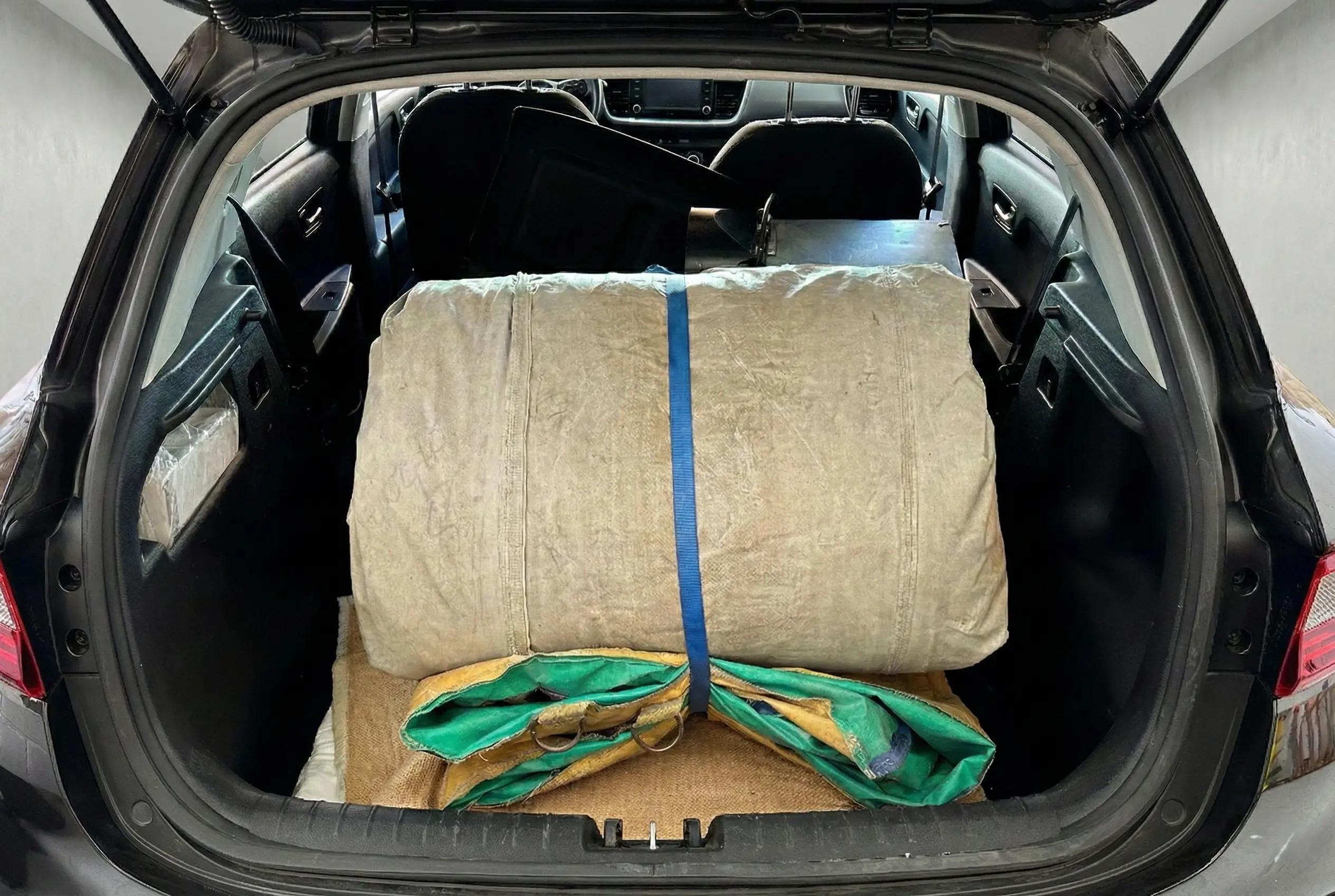 Castillo hinchable mediano plegado dentro del maletero de un coche